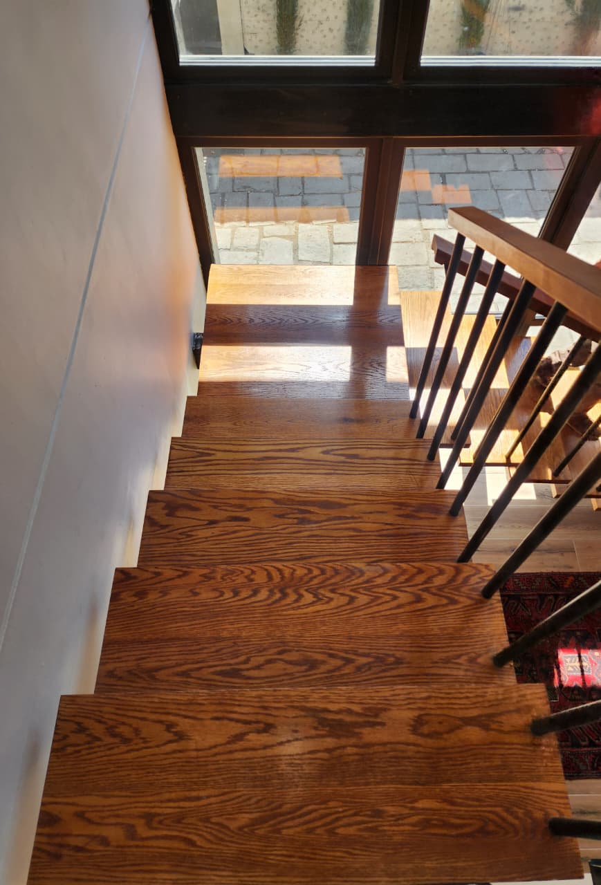 Escalera interior con gradas de madera y estructura metálica